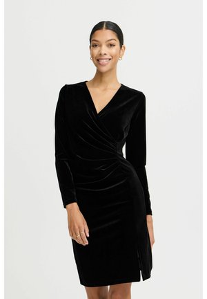 Schwarzes Samt-Wickelkleid mit langen Ärmeln, V-Ausschnitt, seitlichem Raffung und einem hohen Schlitz bis zum Oberschenkel. Glatte Textur und figurbetonter Schnitt.
