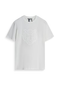 Camiseta blanca de algodón con un diseño de cara de tigre texturizado y en relieve en el pecho. Manga corta y escote redondo.