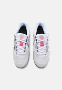 Hvide atletiske sneakers med et mesh-design, lilla accenter og en pink stribet løkke. Har hvide snørebånd og en polstret krave for komfort.