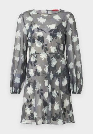 Semi-transparante lange mouwen jurk met zwart-wit bloemmotief, aansluitende taille, ronde halslijn en elastische manchetten.