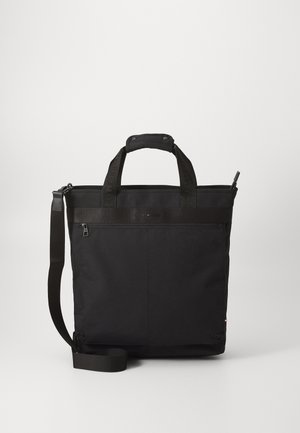 Crna torba na rame izrađena od izdržljive tkanine s dvostrukim ručkama, podesivim remenom za rame, zatvaračem na munje i suptilnim logotipom na prednjoj strani.