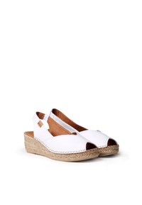 White slingback wedge shoes with open toes, made of synthetic material, featuring a textured jute wedge heel and tan leather insole.