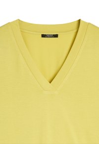 T-shirt z dekoltem w serek w jasnym żółtym kolorze, wykonany z gładkiego materiału. Charakteryzuje się prostym, klasycznym krojem z dekoltem o średniej szerokości. Bez wzorów ani akcentów.