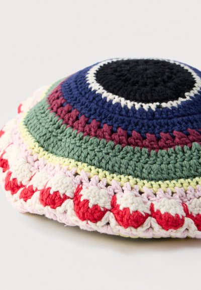 Πλεκτό κιπάχ με συγκεντρικούς κύκλους σε μαύρο, ναυτικό μπλε, λευκό, βουργουνδί, πράσινο, κίτρινο, ροζ και κόκκινο σε λευκό φόντο.