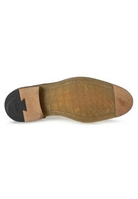 Semelle de chaussure en cuir marron avec un dessous en caoutchouc beige texturé et un talon noir distinctif. Présente une semelle intermédiaire lisse et des accents de marque.
