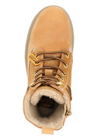 Botas de ante marrón claro con un cuello acolchado, cordones marrones y ojetes dorados. Forro de forro polar visible en el interior con un logo circular en el talón.