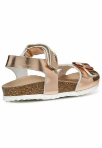 Roze gouden sandalen met een kurken voetbed, voorzien van twee verstelbare banden, een textuur witte zool en een decoratieve strikdetail.