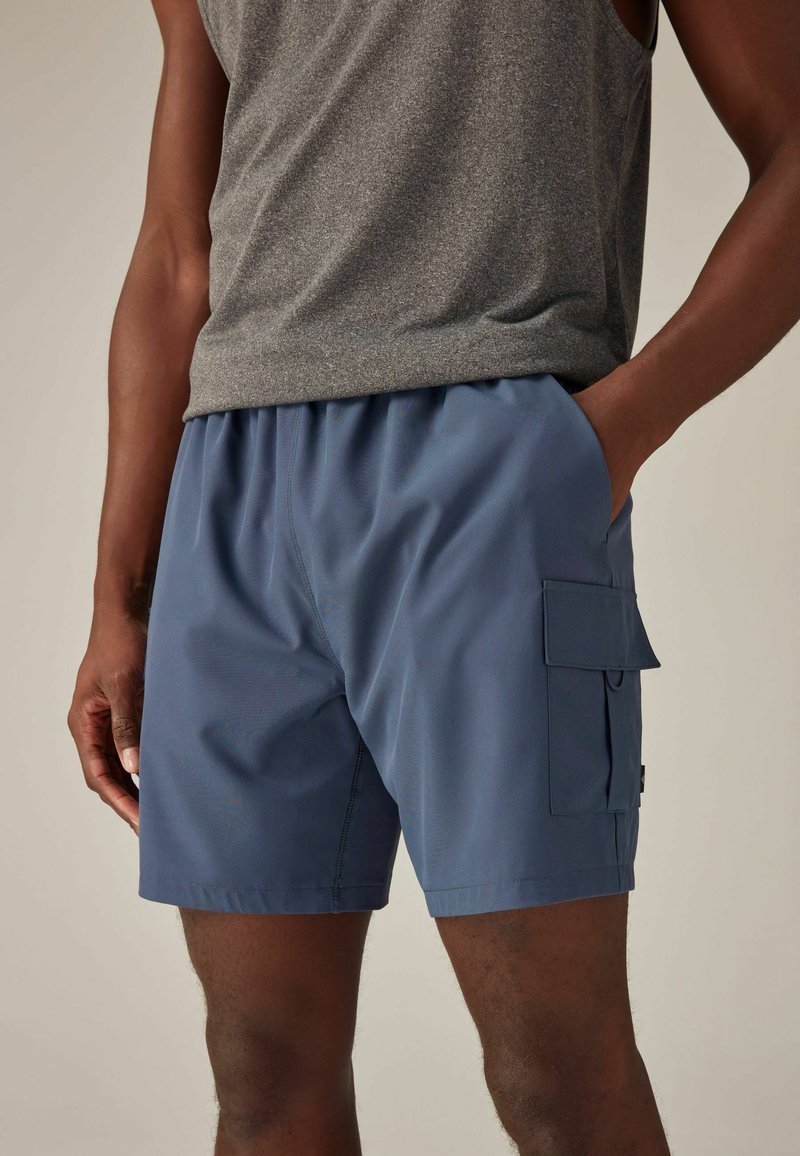 Shorts cargo d'un bleu profond, fabriqués en tissu léger. Présentent des poches latérales avec rabats et une taille élastique pour plus de confort.