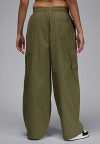 Valkkaavat cargo-housut oliivinvihreänä. Valmistettu kevyestä kankaasta, jossa on joustava vyötärö ja sivutaskut. Silkkinen pinta, rento istuvuus.
