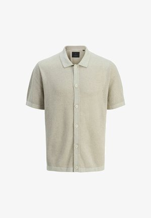 Polo de punto de manga corta en beige claro con un patrón texturizado, cuello redondeado y siete botones frontales para el cierre.