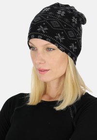 Black beanie hat with gray snowflake patterns, made of soft material. Features a slouchy design and subtle stitching accents.