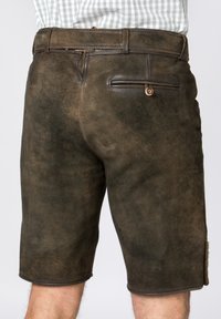 Brune lædershorts med en tekstureret overflade, der har en baglomme med knaplukning og opsmøg i benåbningerne.