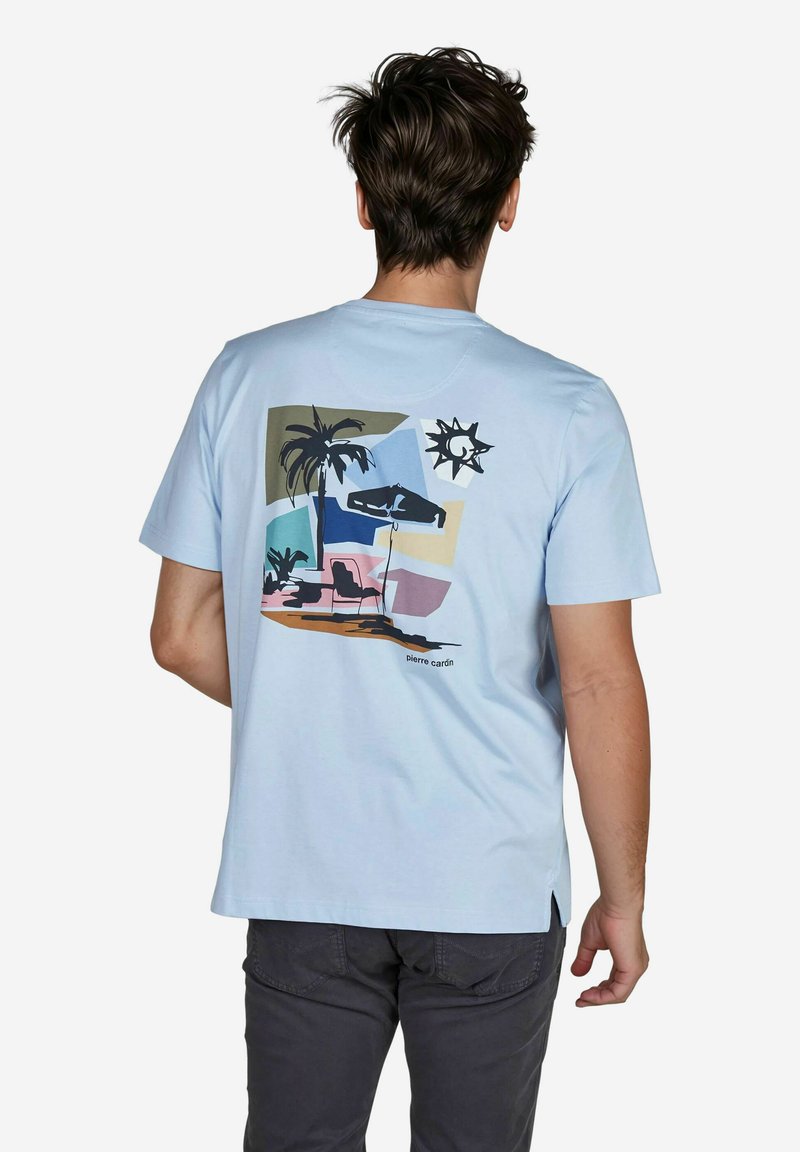 Lichtblauwe katoenen t-shirt met een grafische print van palmboom, zon en stoelen op de achterkant, met zwarte accenten en de tekst "Pierre Cardin".
