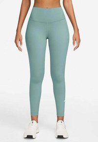 Leggings a vita alta in teal realizzati in un tessuto elastico, con una texture liscia e un piccolo logo bianco vicino alla caviglia.
