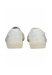 Bílé plátěné tenisky s texturovaným povrchem, zaoblenou zadní částí a kontrastními krémovými gumovými podrážkami. Minimalistické ozdoby na bocích.