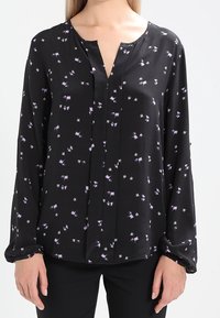 Černá blůza s malým purpurovým květinovým potiskem, dlouhými rukávy a knoflíkovým zapínáním. Vyrobena z lehkého materiálu s hladkou texturou.