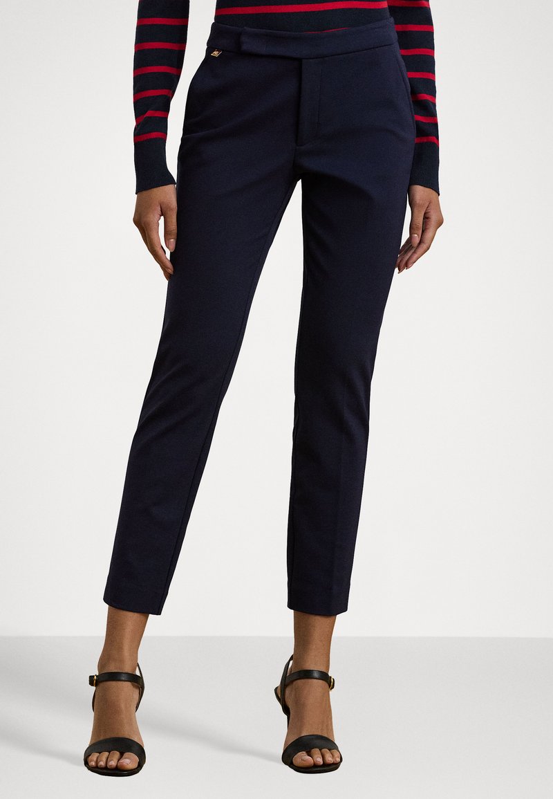 Navy tailored trousers with a high waistband, slim fit, and slanted pockets. Pair with black strappy heels for a chic look.
