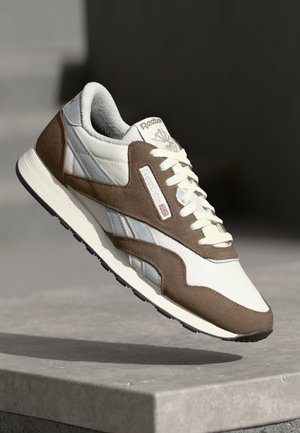 Braunes und weißes Sport Schuhwerk aus Leder und Wildleder, mit Schnürdesign, gepolstertem Schaft und Gummisohle mit strukturiertem Profil.