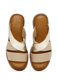 Beige leren sandalen met twee metalen en gestructureerde kruisschoenen, platte zolen en gestikte afwerking langs de randen.