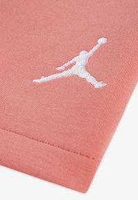 Ύφασμα από βαμβάκι σε κοραλί απόχρωση με λευκό κεντημένο λογότυπο Jumpman. Η υφή είναι απαλή με ραμμένο τελείωμα στο κάτω άκρο.