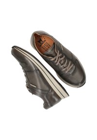 Baskets gris foncé avec un dessus en cuir texturé, des détails perforés, des lacets plats et une semelle blanche contrastante. Présente le logo de la marque à l'intérieur.
