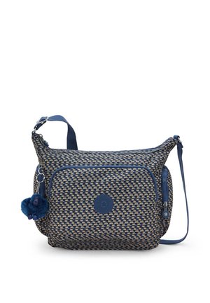 Blue and beige woven fabric shoulder bag with a front zip pocket, a round logo patch, and a furry blue charm attached.