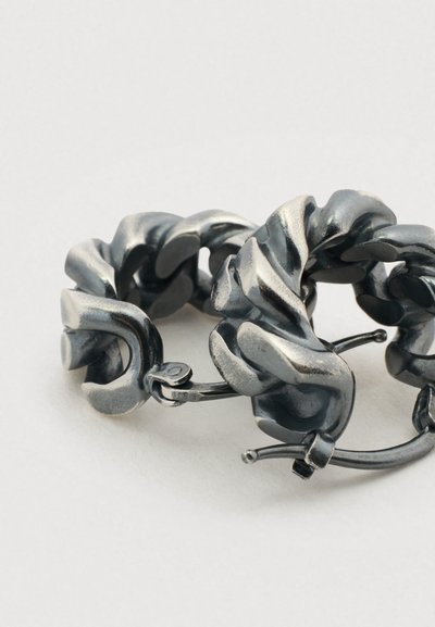 Σκουλαρίκια κρίκοι από μέταλλο με σχεδιασμό στριφτό σε μεταλλικό γκρι φινίρισμα, που αναδεικνύουν ομαλές υφές και διακριτική λάμψη.