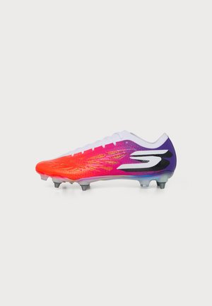 Une chaussure de football aux couleurs vives, avec des crampons, présentée de profil sur un fond uni. Sa tige passe de l’orange au rose puis au violet, avec un grand logo noir et blanc.