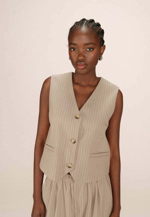 Gilet rayé gris avec un décolleté en V, trois boutons et deux poches avant. Le tissu a une texture lisse, porté sur une jupe froncée.