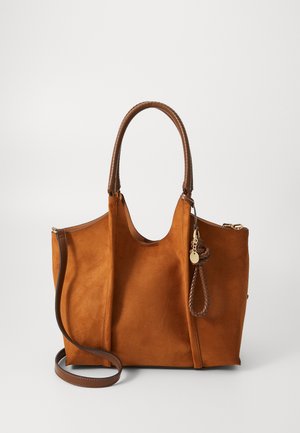 Brown suede tote bag with dual brown handles, side zipper detail, and a detachable charm. Features a smooth texture and structured shape.