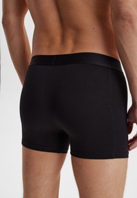 Svarta bomullsboxer med en tät passform. Har en mjuk elastisk midja och sömlösa kanter för komfort och en smidig look.