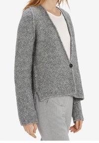 Šedý kardigan z vlněné směsi s hlubokým výstřihem do V, zapínáním na jeden knoflík a bočními rozparky. Má měkkou, strukturovanou tkaninu a volný střih.