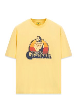 Gelbes kurzärmeliges T-Shirt mit einer Grafik einer Frau, die ein Guess-Logo hält, mit dem Text „hysteric GLAMOUR“ unter einem Retro-Sonnenuntergangskreis.