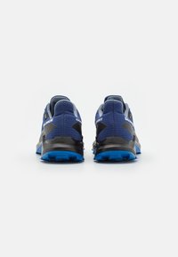 Chaussures de trail de course bleu et gris avec une tige en maille texturée, une semelle noire rembourrée et une semelle extérieure bleue avec des crampons pour une meilleure adhérence.