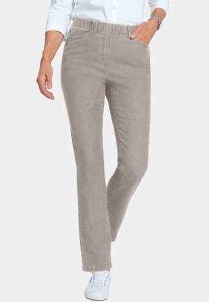 Lichtbruine, gestructureerde broek met een elastische tailleband, recht model en zijzakken, gecombineerd met witte sneakers.