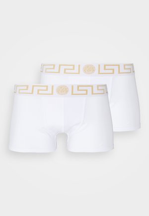 White boxer briefs with a gold Greek key pattern and a medusa logo on the elastic waistband. Made of soft, stretchy fabric.