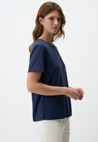Donkerblauwe t-shirt met korte mouwen van zachte stof, met een klassieke ronde hals en een relaxte, rechte pasvorm. Geen zichtbare patronen of logo's.
