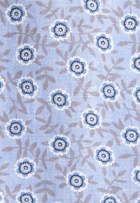 Tissu bleu clair avec petits motifs floraux bleu foncé et blanc et branches feuillues gris clair dispersées un peu partout.