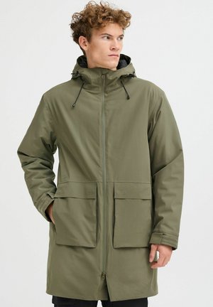 Olivengrønn, vannavstøtende parka med glidelås foran, justerbar hette, to store frontlommer og elastiske mansjetter. Glatt, slitesterkt stoff.