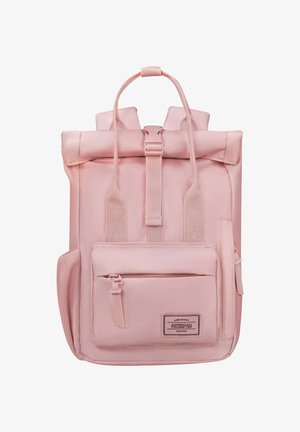 Pink roll-top backpack with front zippered pocket, side mesh pocket, padded shoulder straps, and American Tourister logo patch.