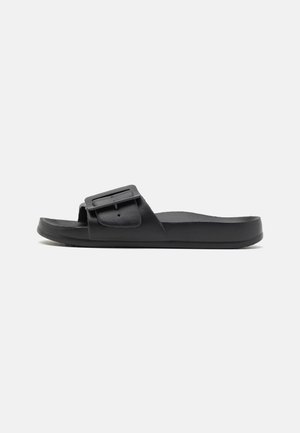 Black slide sandal with a wide strap, adjustable buckle, flat sole, and smooth matte texture. Simple design without additional patterns.