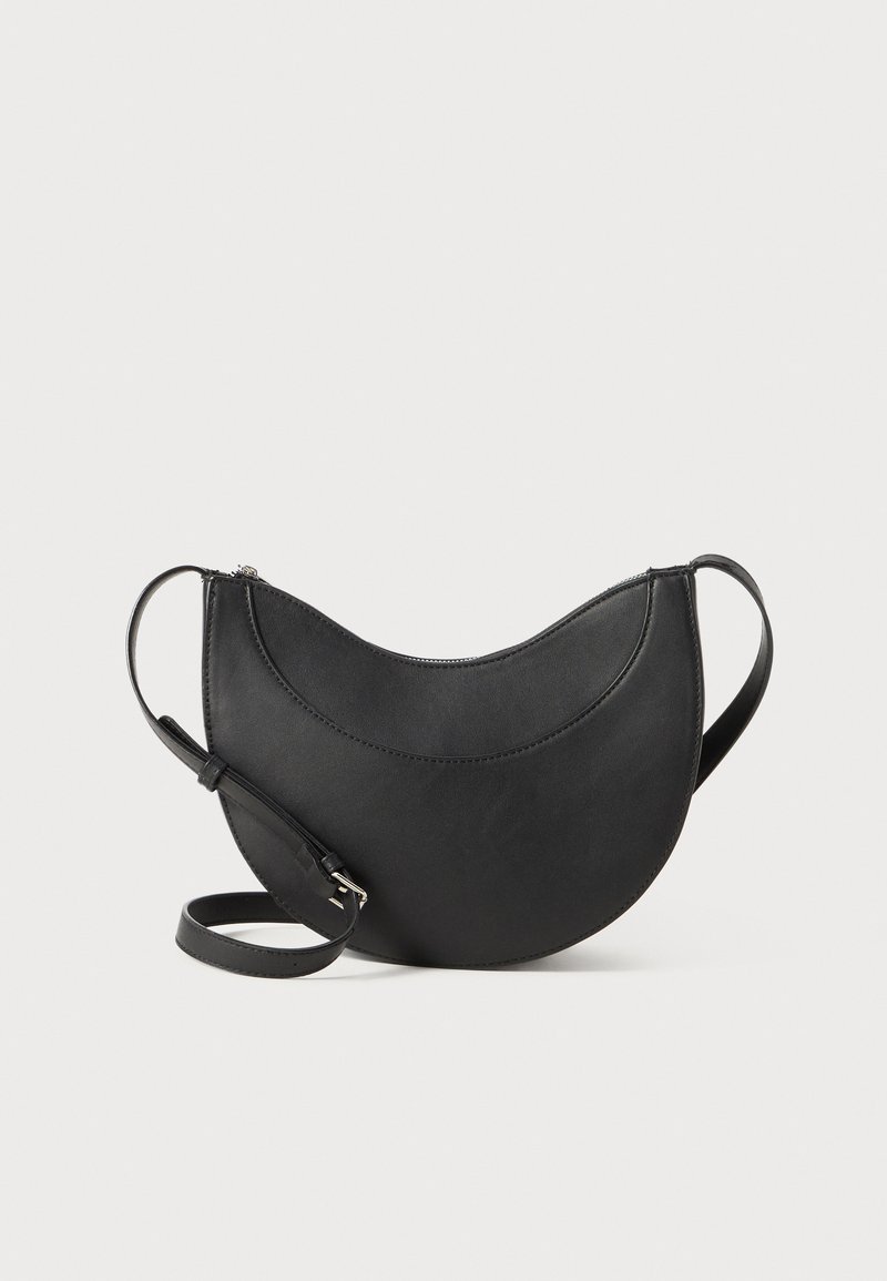 Black leather bag in a moon shape with a zip closure, featuring two handles and a smooth texture. Minimalist design with no additional accents.