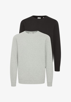 Sweat à capuche gris clair avec des poignets et un ourlet côtelés, associé à un short assorti. Porté avec des chaussures de sport multicolores. Design simple et épuré.