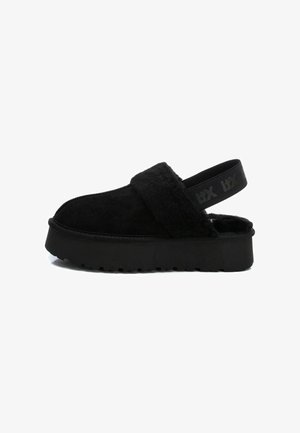 Sandali slingback neri con piattaforma, upper in morbido pelo, suola in gomma spessa e cinturino regolabile con logo in rilievo.