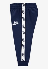 Σκούρα μπλε φόρμα με λευκό λογότυπο Nike και ριγέ λεπτομέρειες στο πλάι. Διαθέτει ελαστική μέση και σχέδιο με στενό κάτω μέρος στα πόδια. Μαλακή υφή υφάσματος.