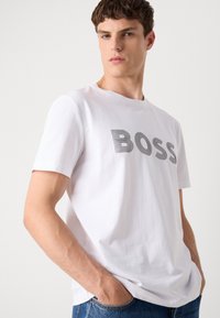 Witte katoen t-shirt met een opvallend "BOSS" logo in grijze lijnen, korte mouwen en een klassieke ronde hals.