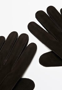 Guanti scamosciati marrone scuro con texture liscia, design a cinque dita e cuciture a contrasto lungo i bordi.