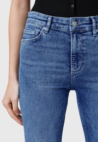 Blauwe spijkerbroeken met een slim fit, voorzien van een middelhoge taille, subtiele wassing en een klein voorvak. Gemaakt met een zachte textuur.