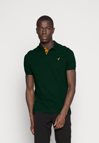 Dunkelgrünes Poloshirt mit einem gelben Knopfkragen und einem kleinen gestickten Logo auf der linken Brust. Kurze Ärmel und eine klassische Passform.