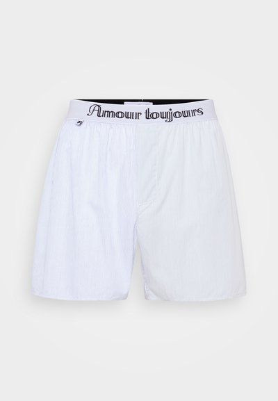 White striped boxers with an elastic waistband featuring "Amour toujours" in black text. Lightweight fabric, loose fit design.